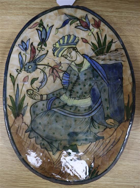 A Persian fritware oval plaque, Qajar dynasty